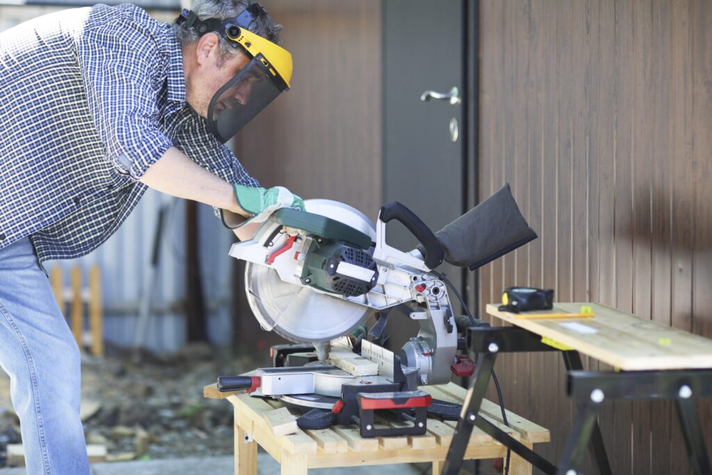 Professional Fence Contractor cutting a wood plank